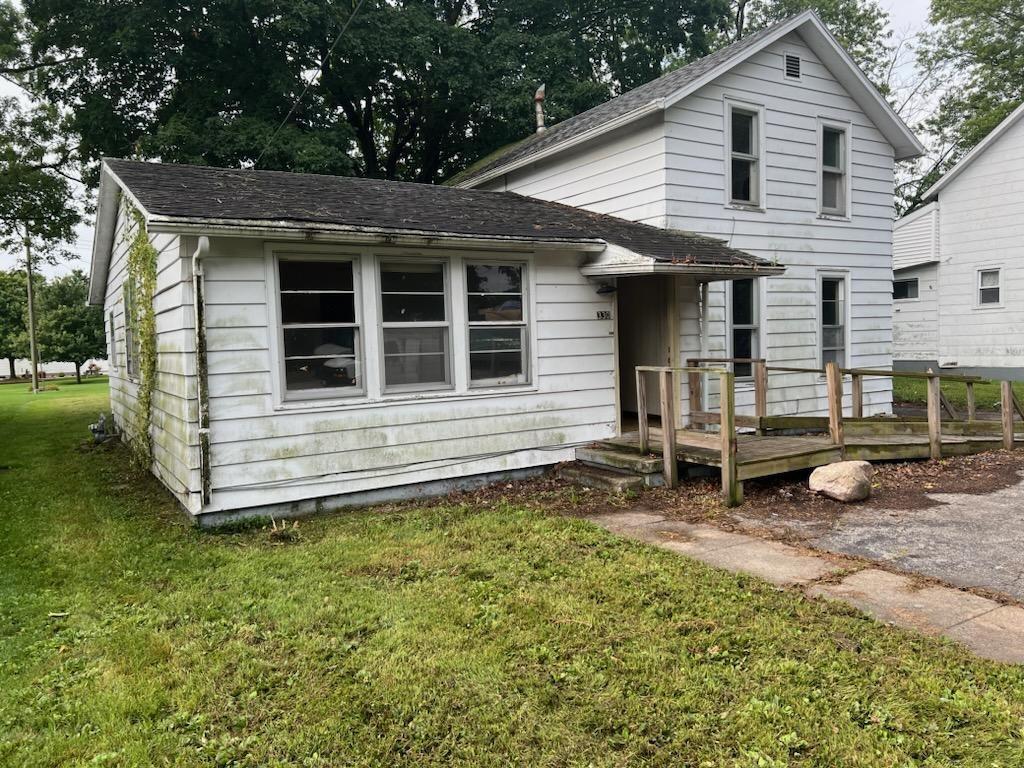 a view of a house with a yard and wooden fence