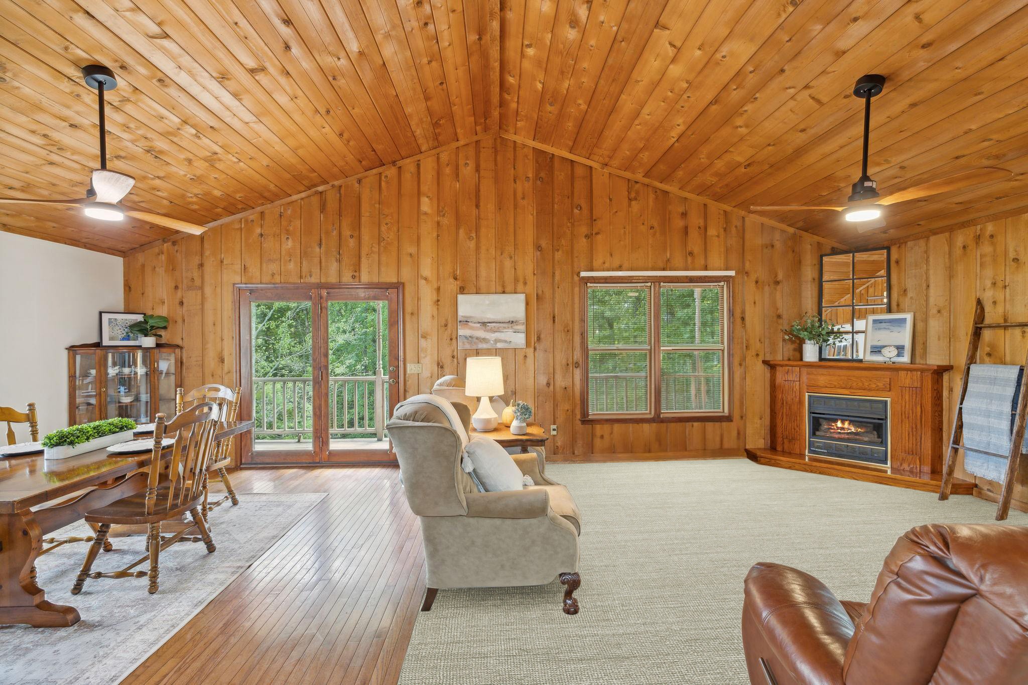 a living room with furniture a fireplace and a floor to ceiling window