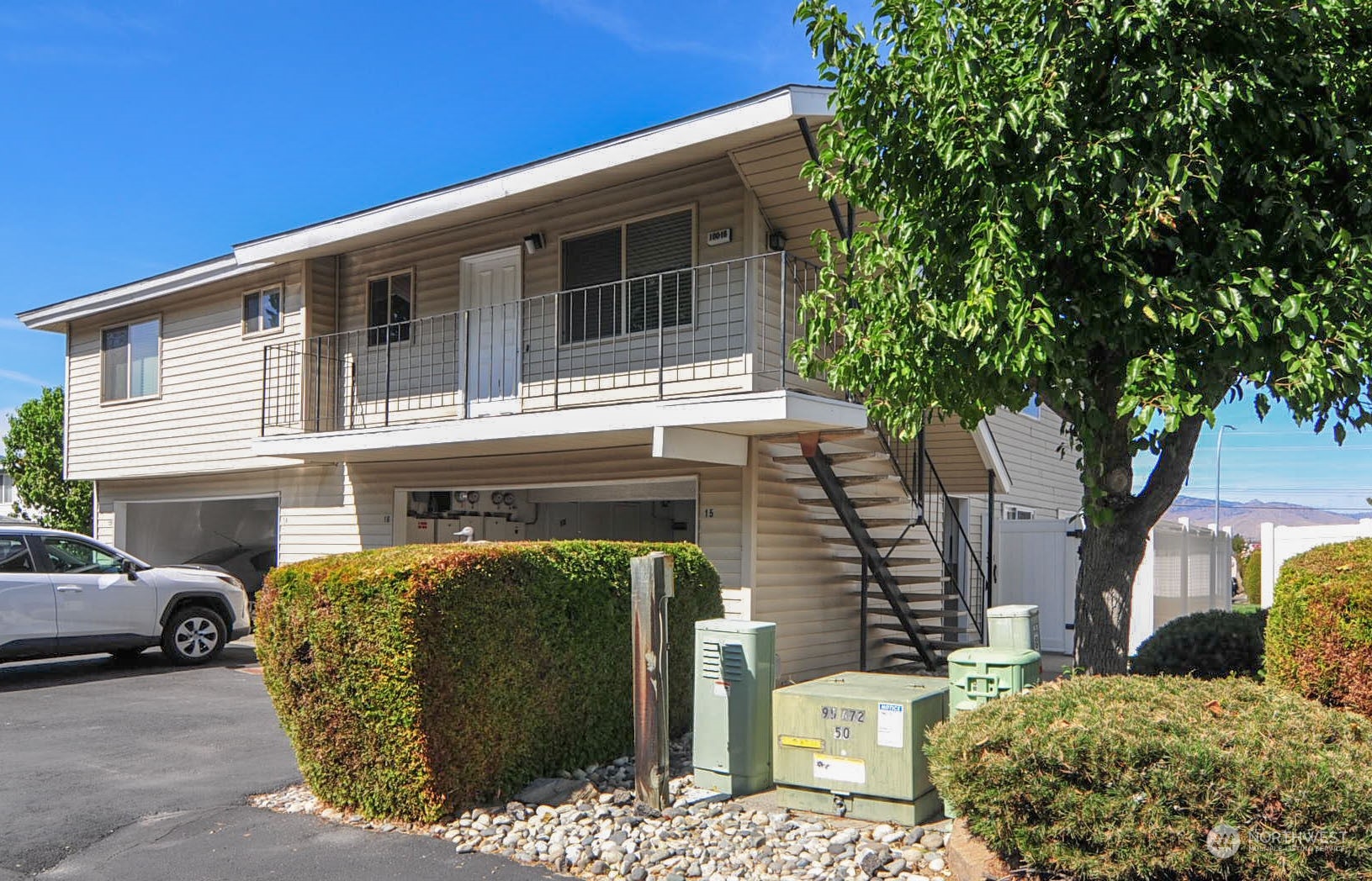 a front view of a house with parking plants