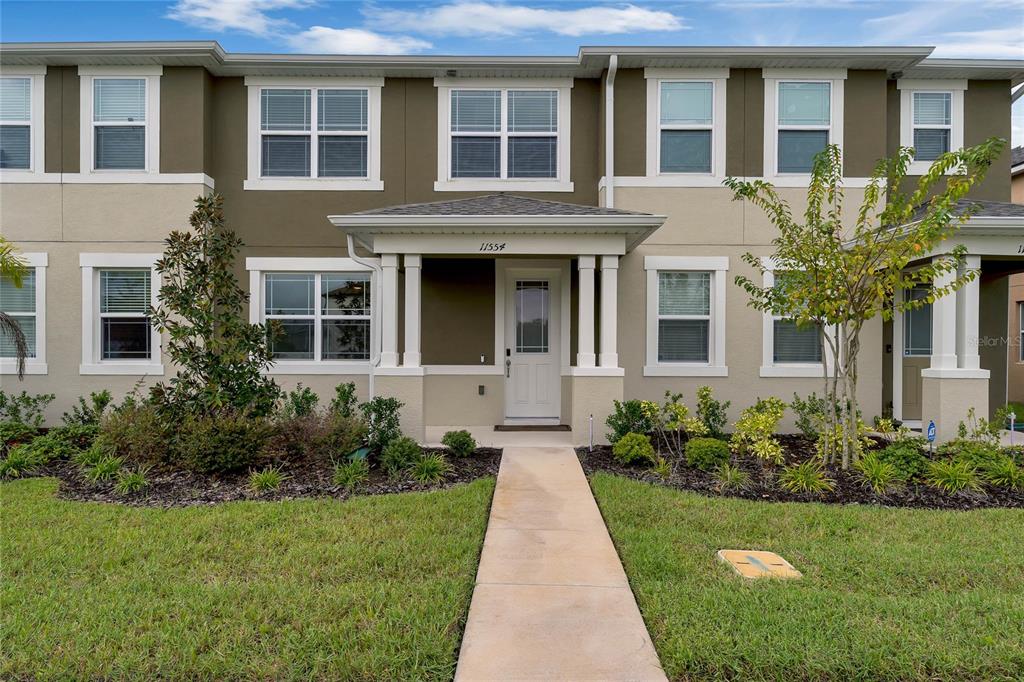 a front view of a house with yard and green space