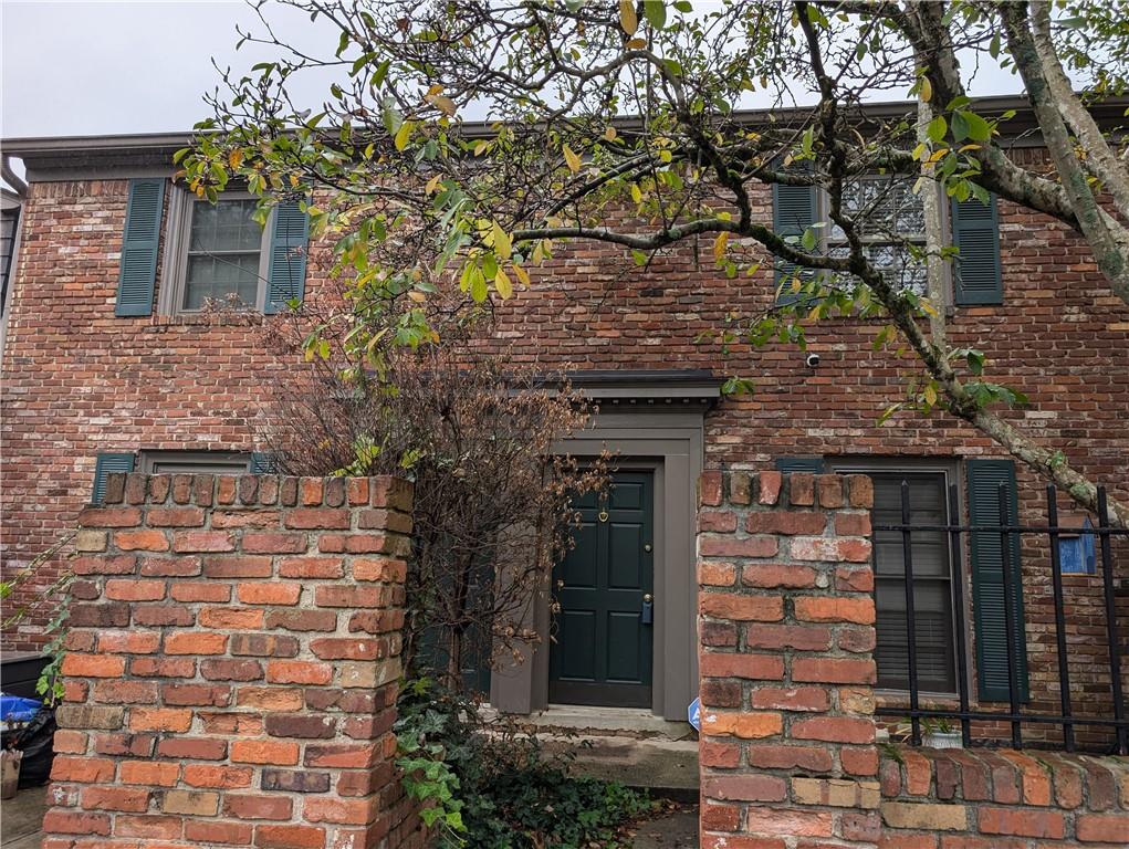 a front view of a house with a tree