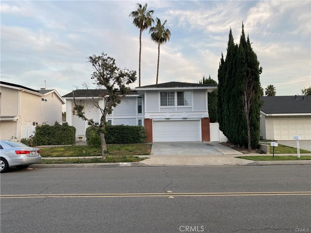 a front view of a house with a garden and yard