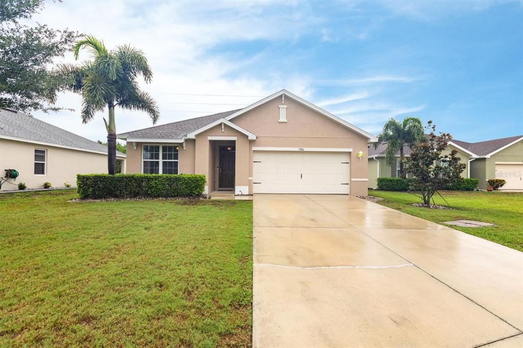 a view of a house with a yard and palm trees