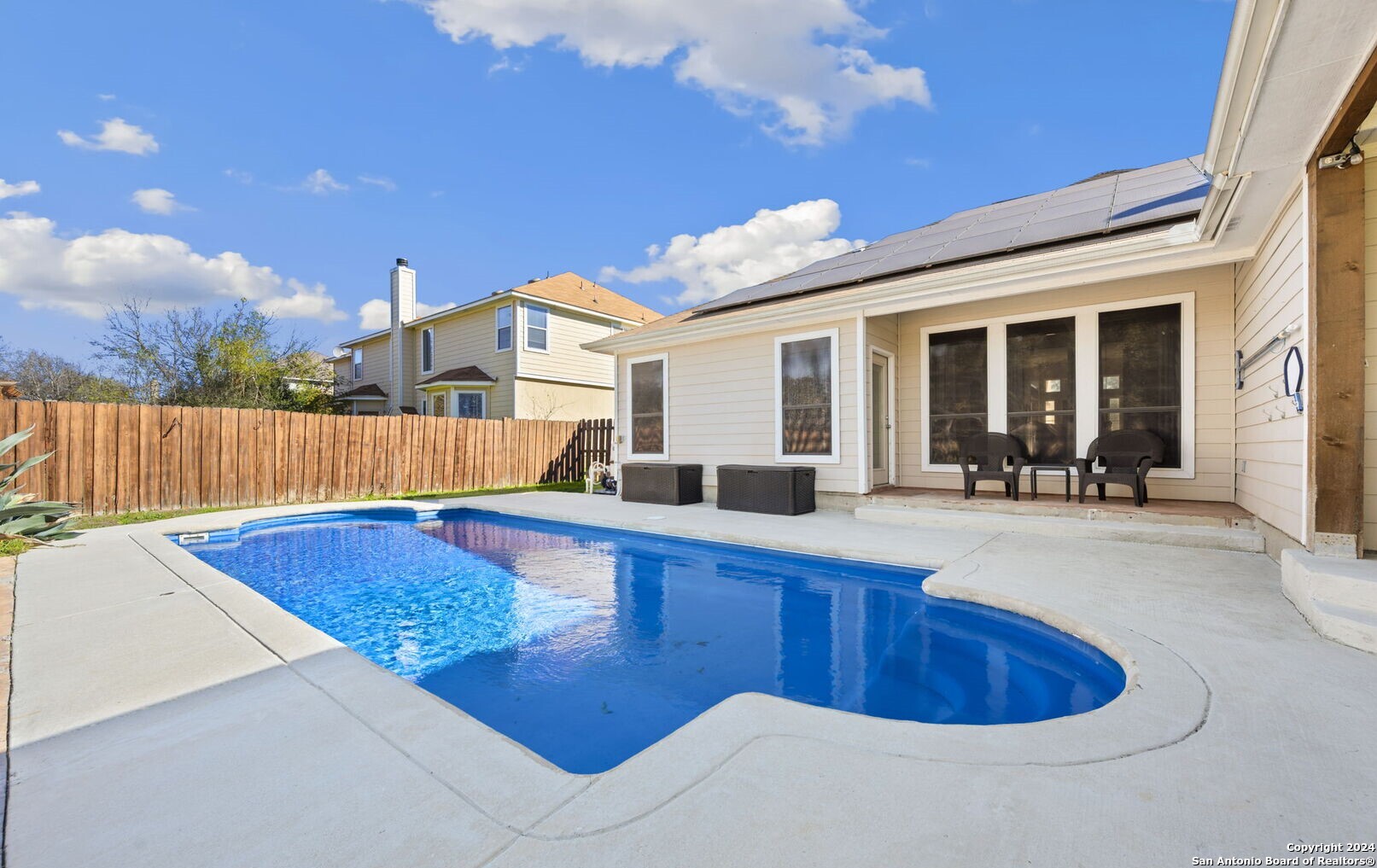 a view of a house with swimming pool and sitting area