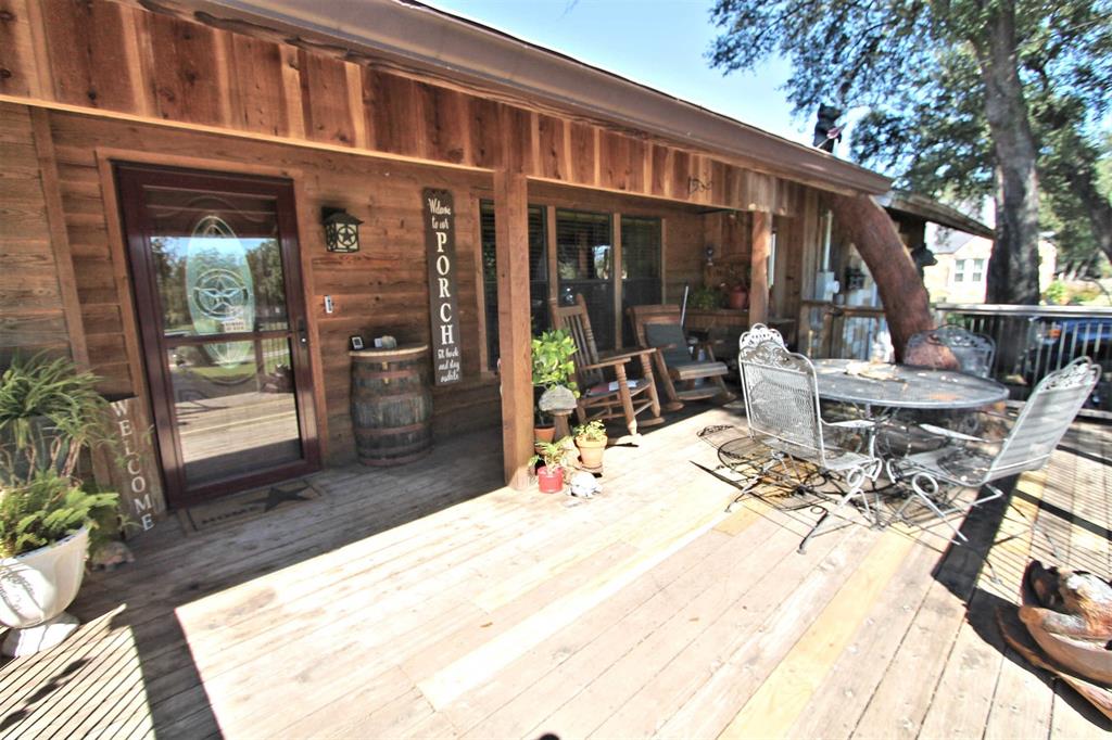 a view of a patio with table and chairs near a barbeque