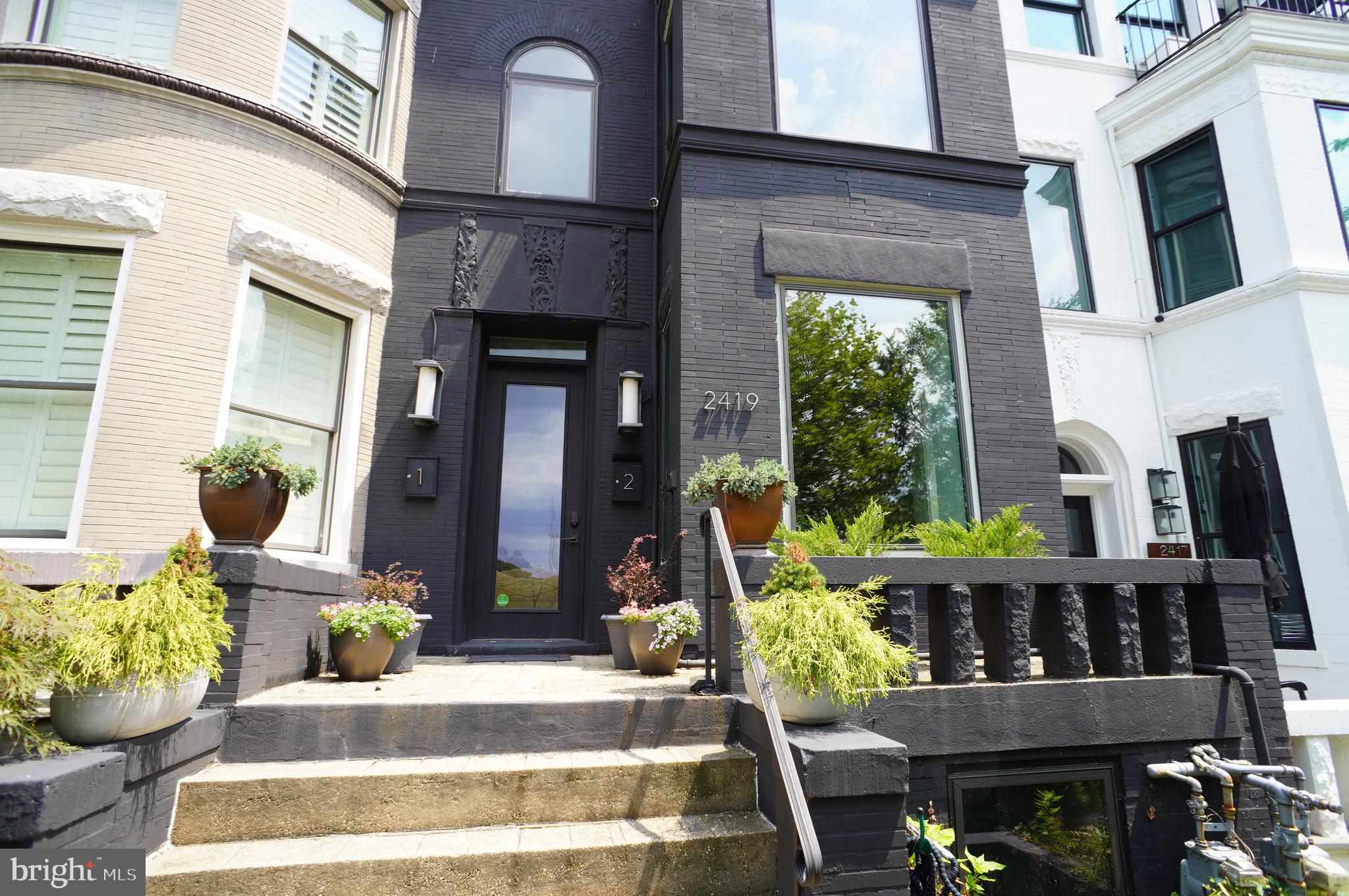 a front view of a house with outdoor seating and plants