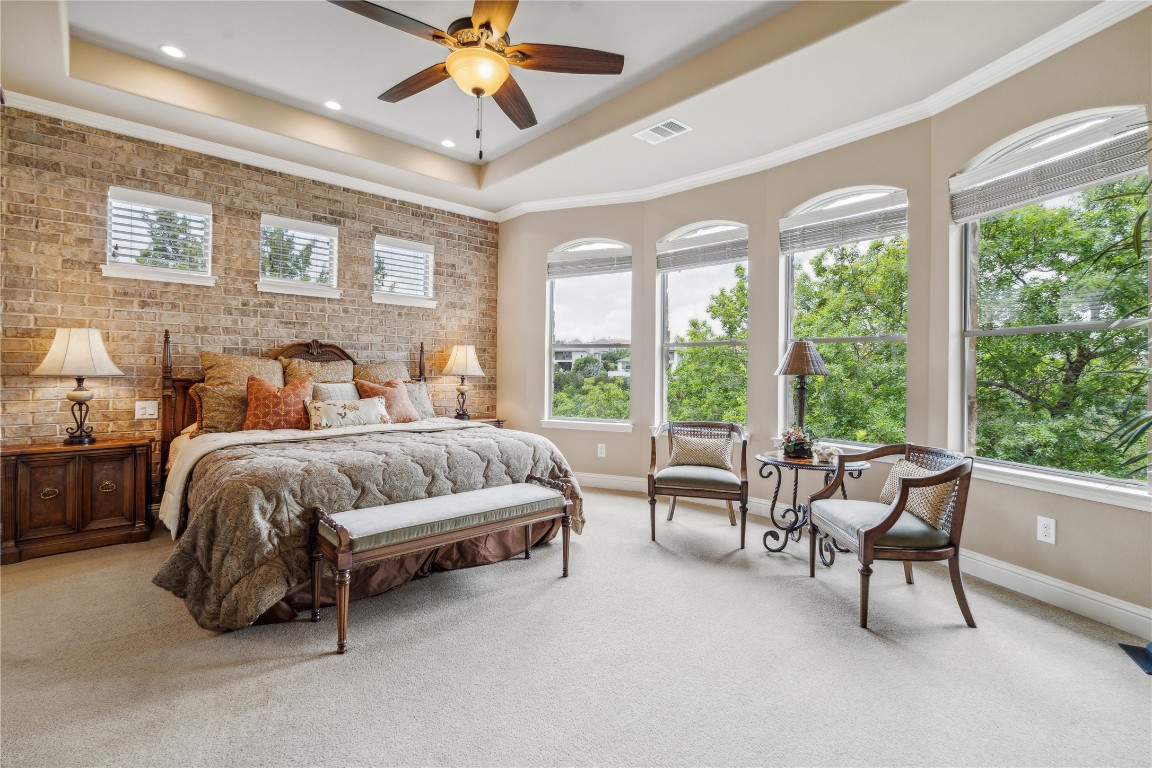 a bedroom with a bed and large windows