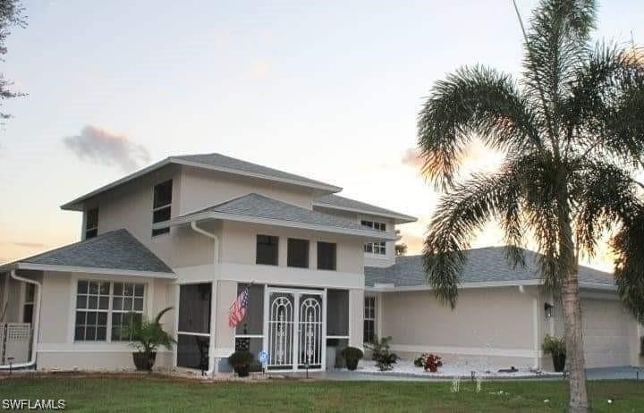 a front view of a house with a garden and trees