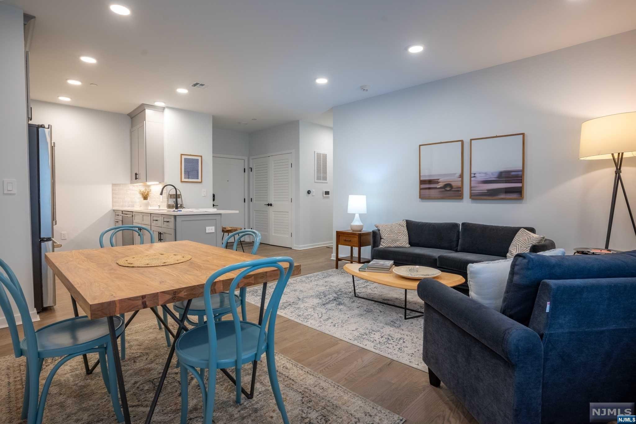 a living room with furniture and a dining table with kitchen view