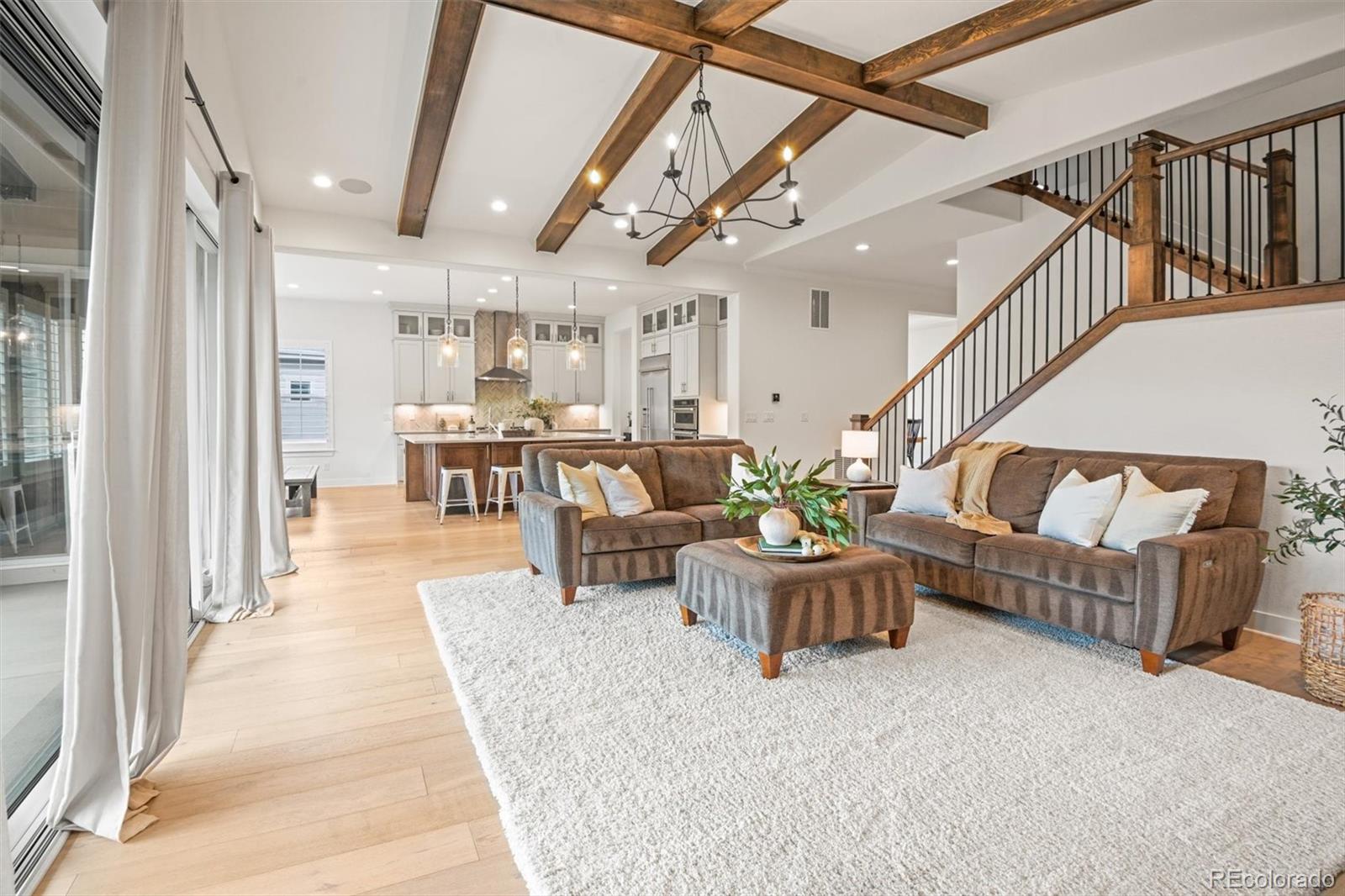 a living room with furniture and a dining table with wooden floor