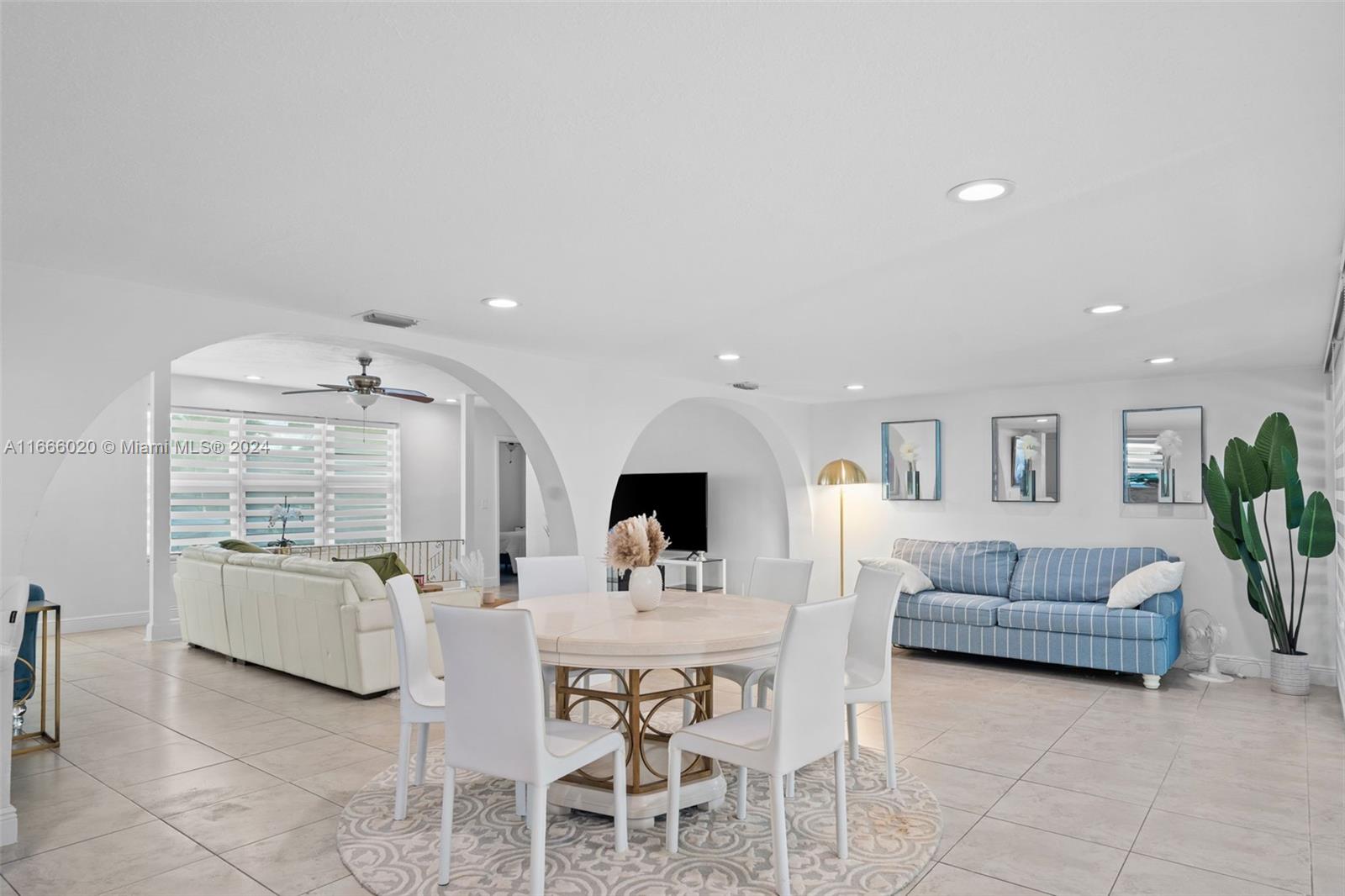 a living room with furniture kitchen view and a wooden floor