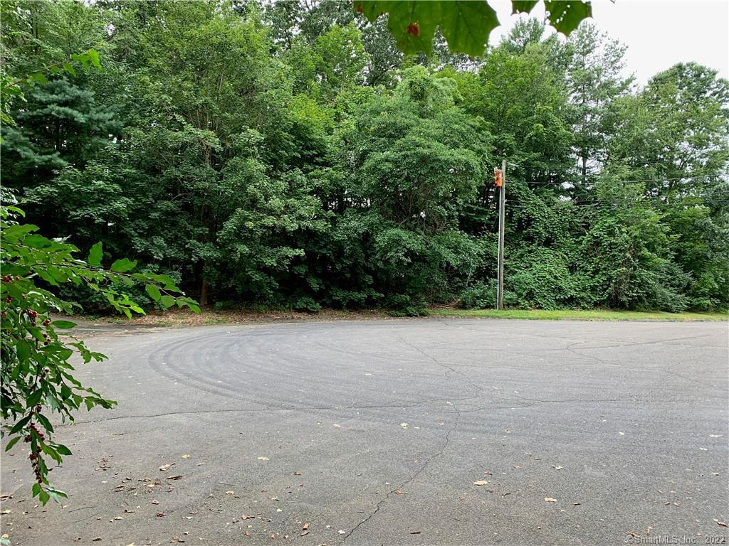 a view of a green field with trees in the background