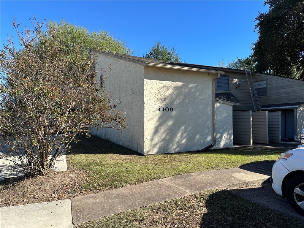 View of side of home with a yard