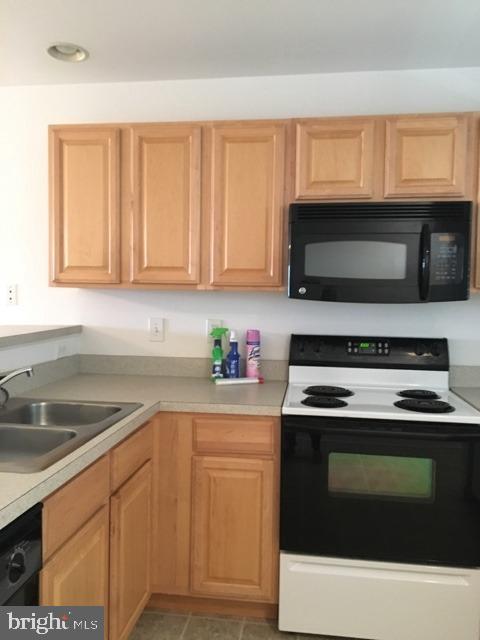 a kitchen with granite countertop a sink stove and microwave