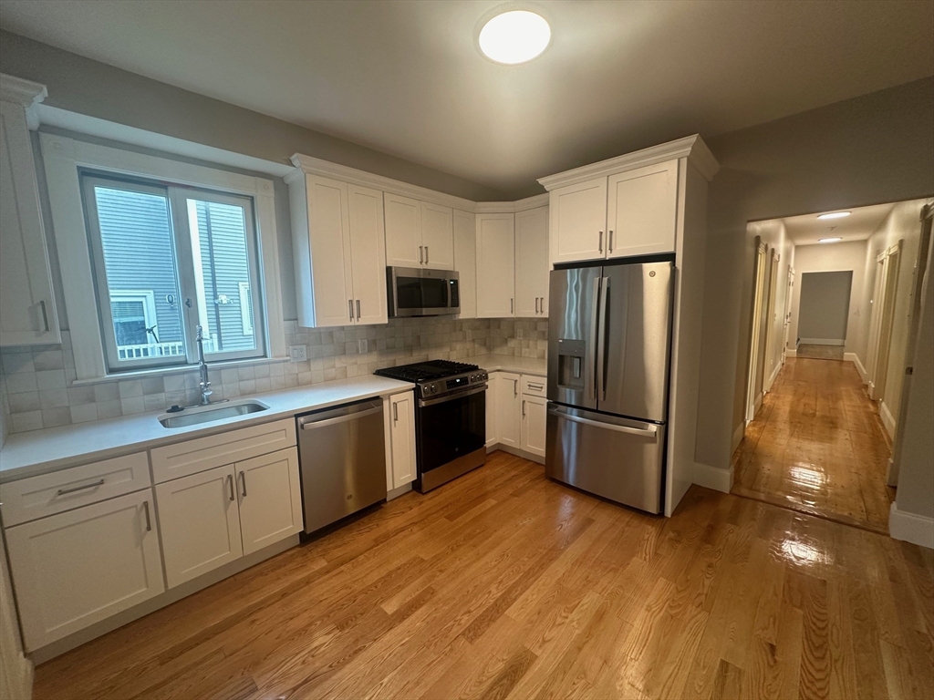 a kitchen with a refrigerator a sink and cabinets