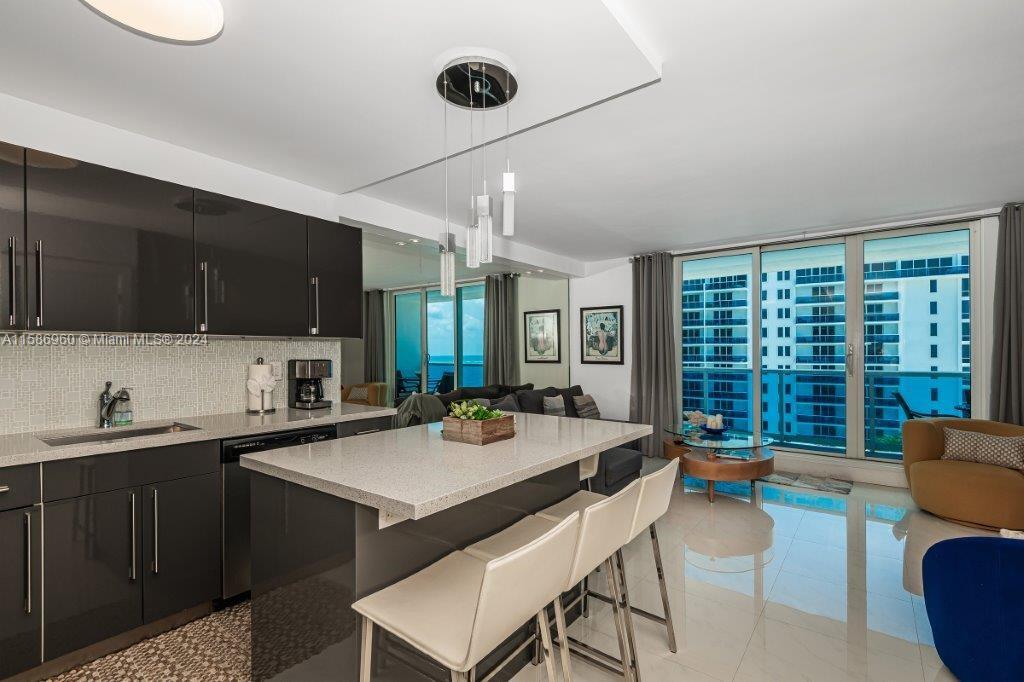 a open kitchen with a sink a stove and chairs with wooden floor