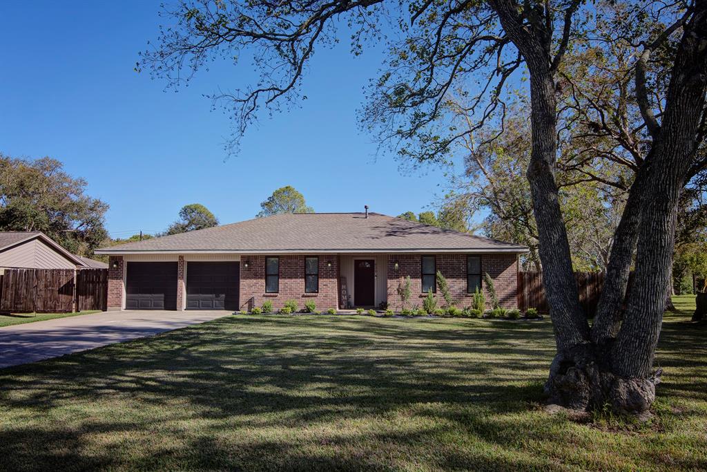 Welcome Home to 620 Tarpey. This single-story brick home has a large front yard, mature trees, and an attached two-car garage.