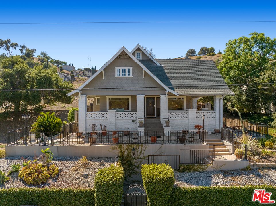 a front view of a house with a yard and potted plants