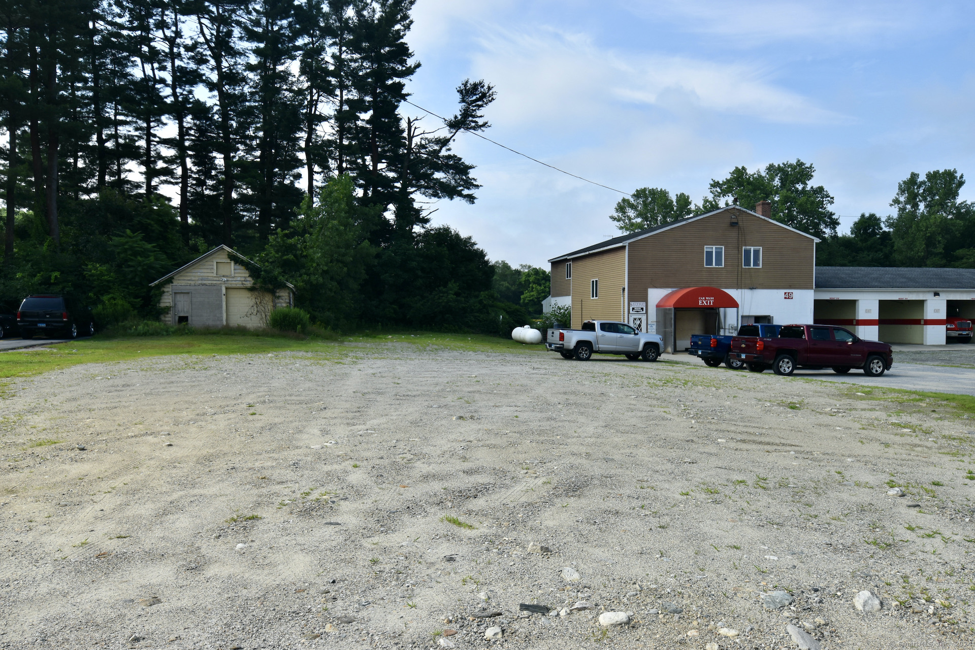 a front view of a house with a yard and trees