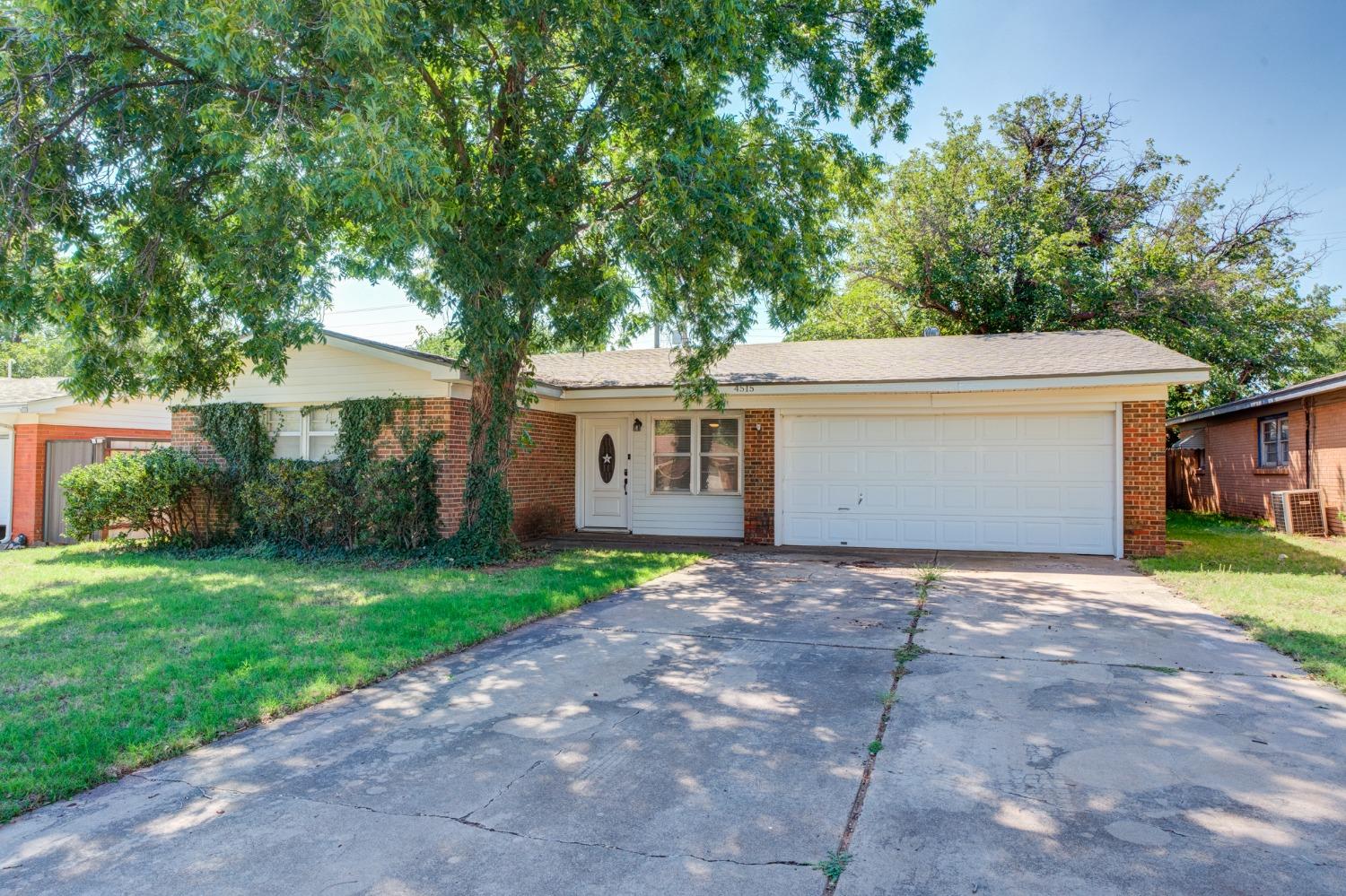 a front view of a house with a yard and a garage