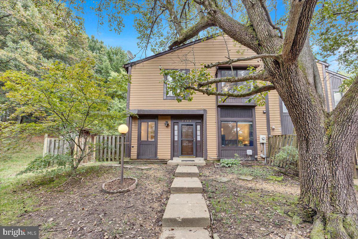 a front view of a house with a tree