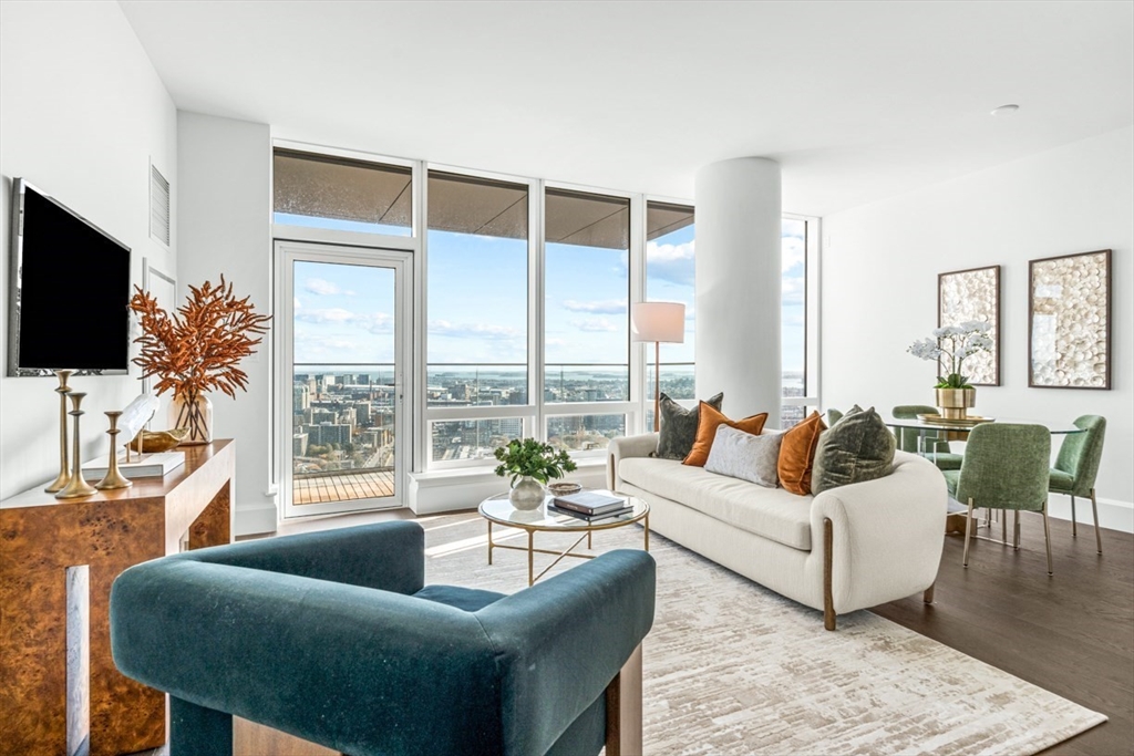 a living room with furniture a flat screen tv and a large window