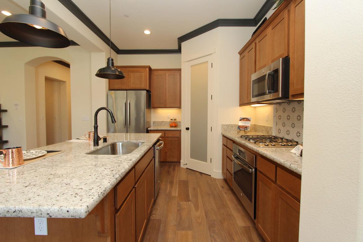 a kitchen with stainless steel appliances granite countertop a sink stove and refrigerator