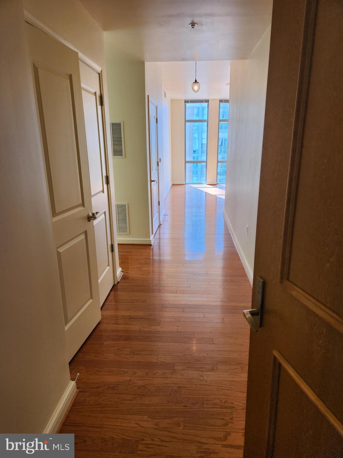 a view of a hallway with wooden floor and staircase