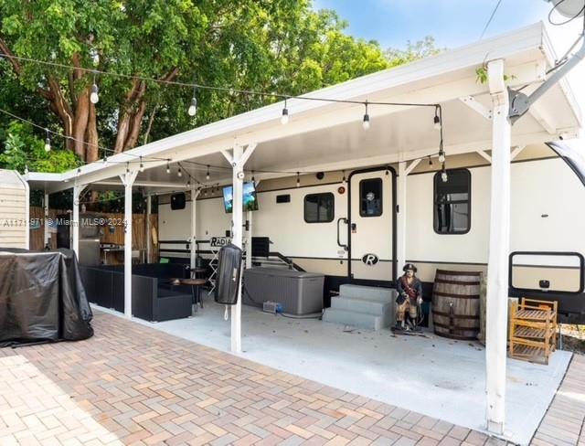 a backyard of a house with barbeque oven and outdoor seating