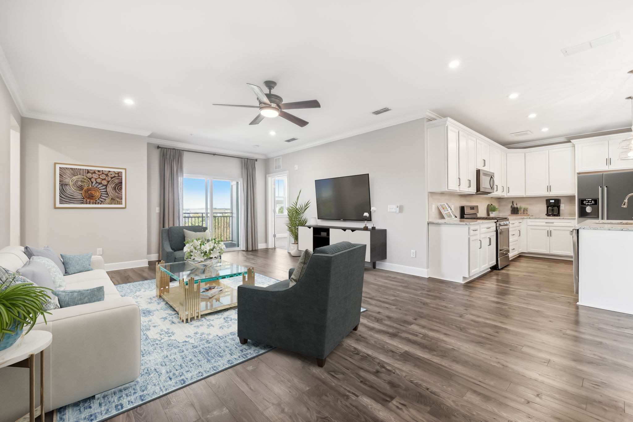 a living room with furniture kitchen and a flat screen tv