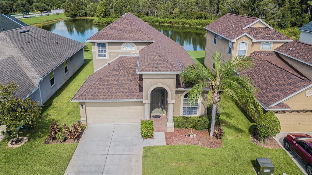 a aerial view of a house with a yard and potted plants