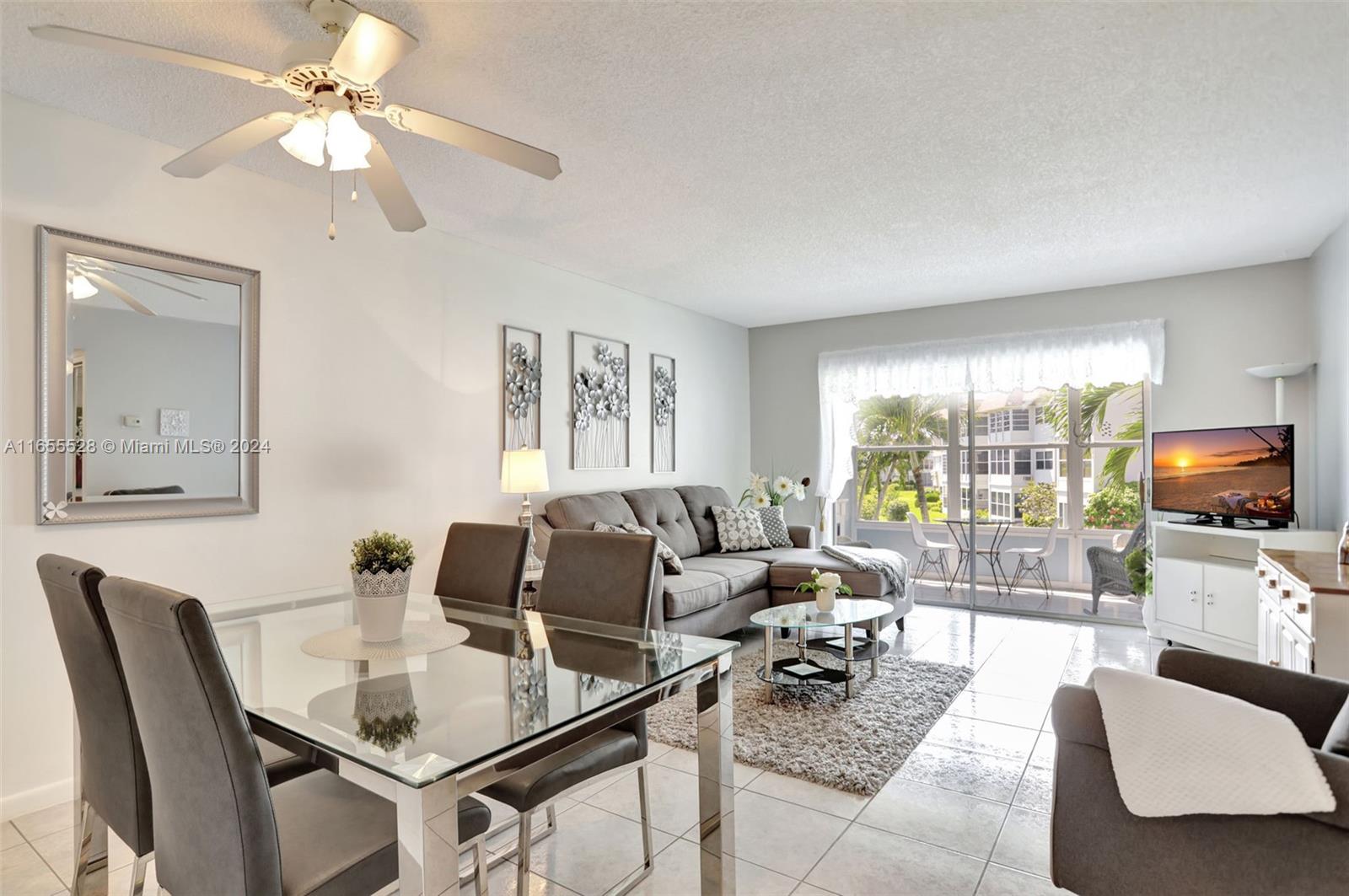 a living room with furniture a flat screen tv and a large window