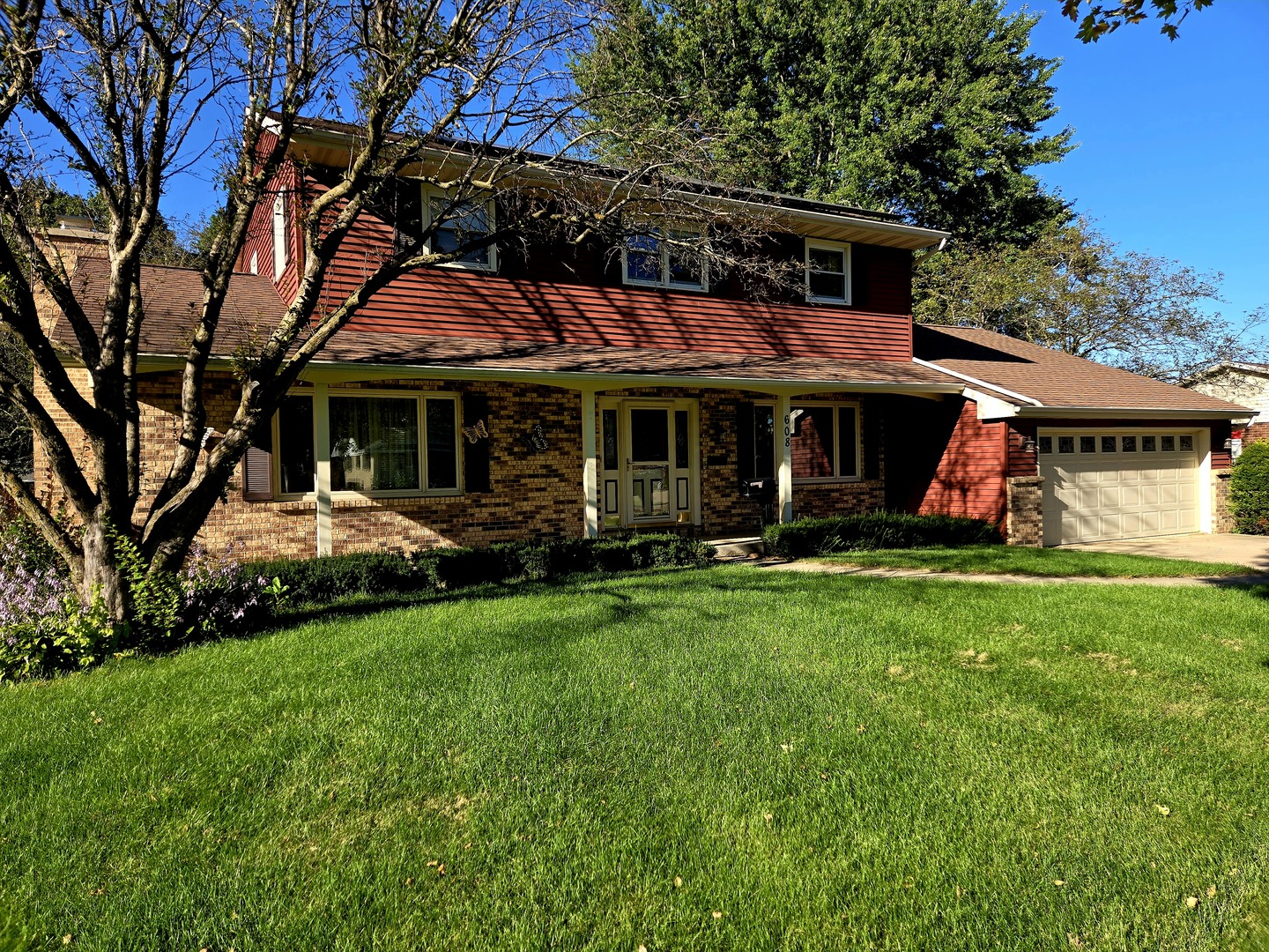 a view of a white house with a big yard and large trees