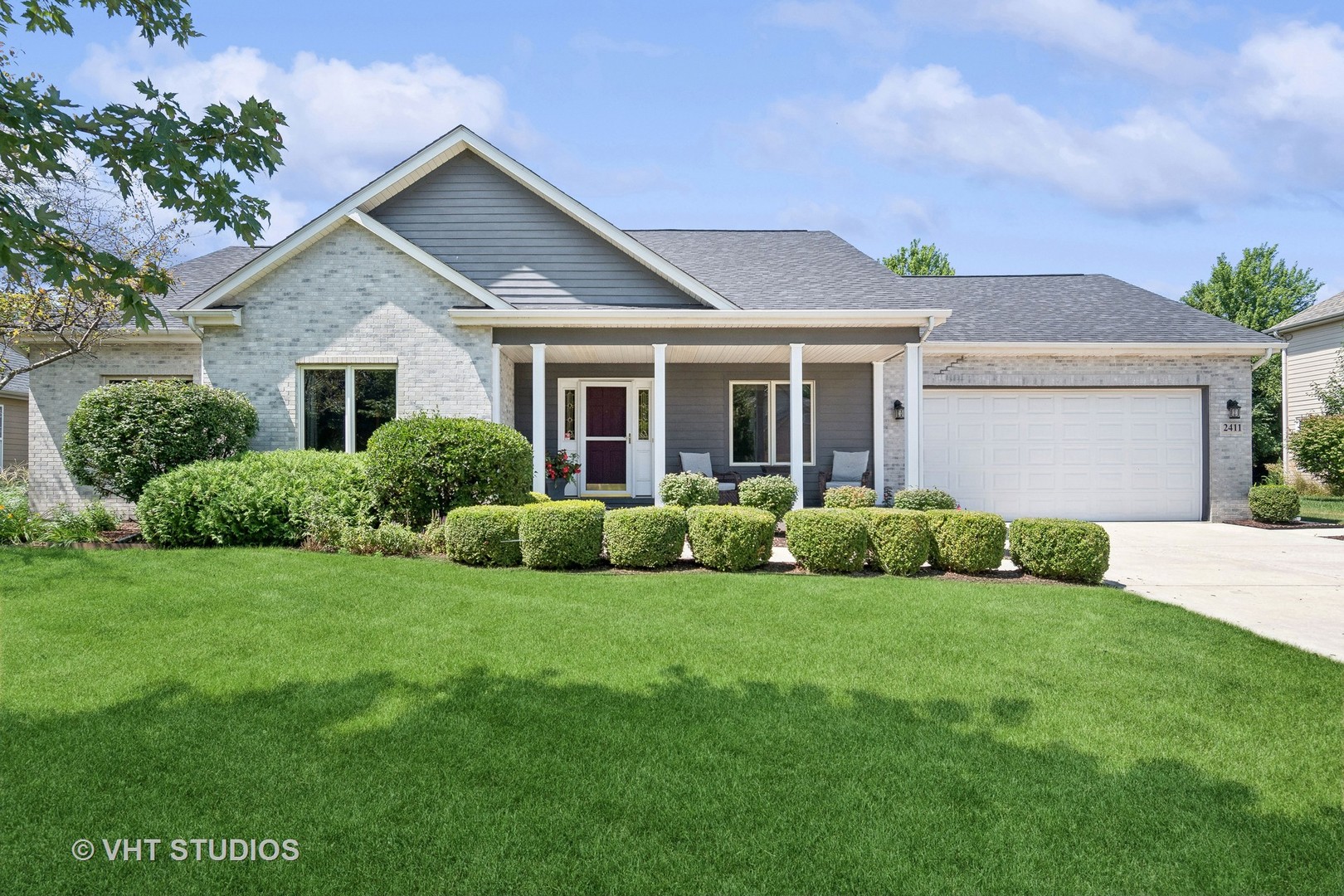 a view of a house with a yard and potted plants