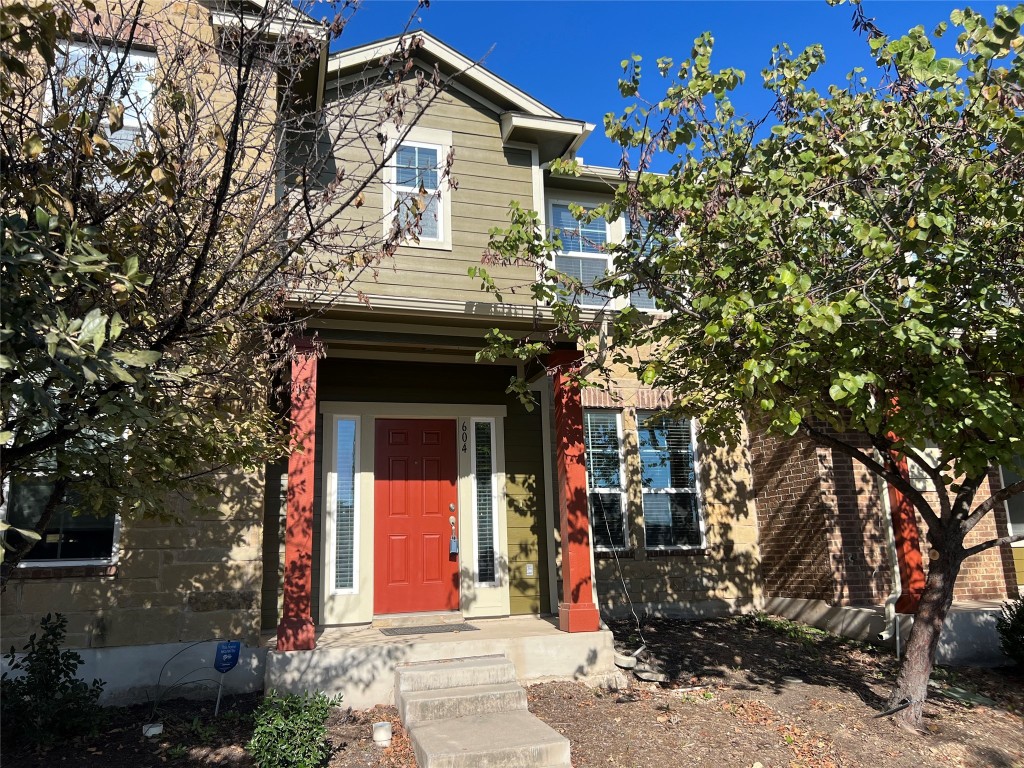 a front view of a house with a tree