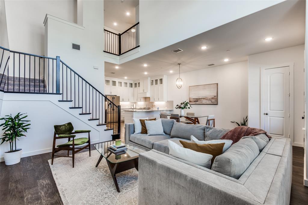 a living room with furniture kitchen view and a wooden floor