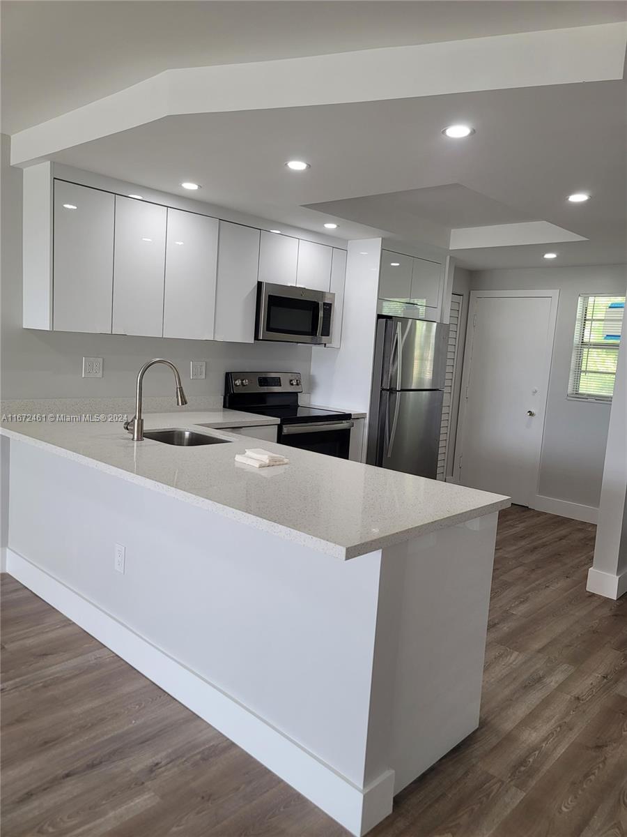 a kitchen with stainless steel appliances a refrigerator sink and microwave