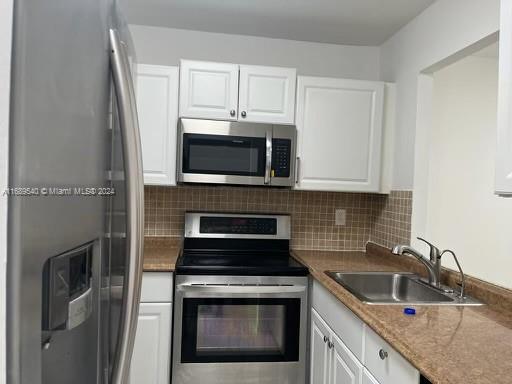 a kitchen with stainless steel appliances granite countertop a stove microwave and sink