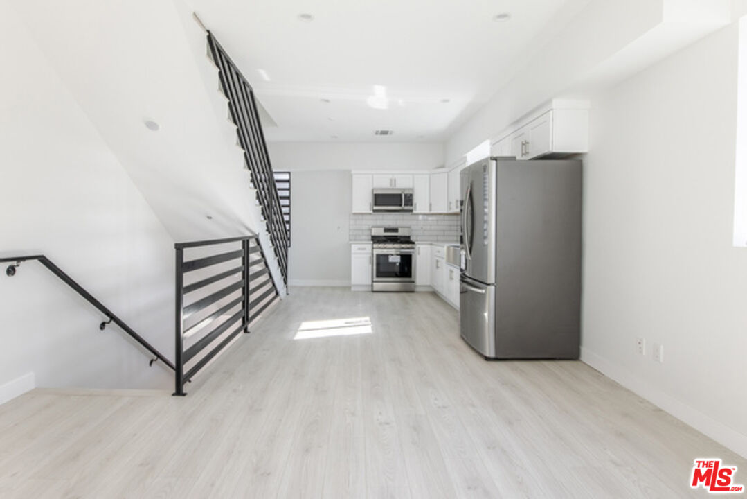 a view of kitchen with furniture and refrigerator