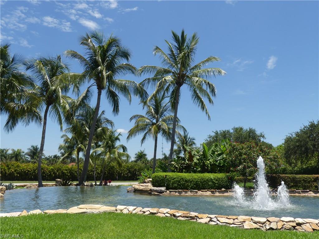 a front view of a house with a yard and palm trees