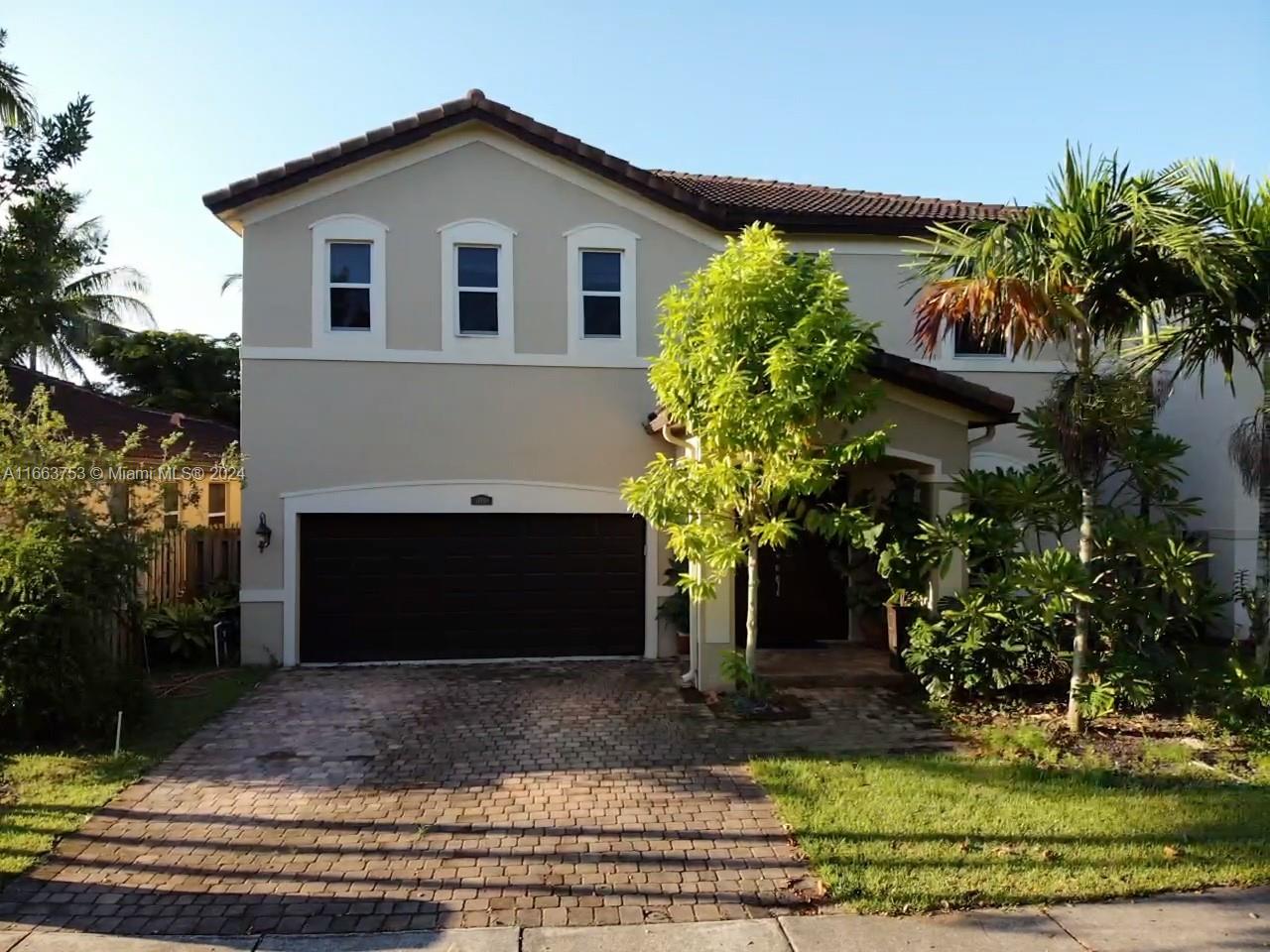 a front view of a house with a yard garage and outdoor seating