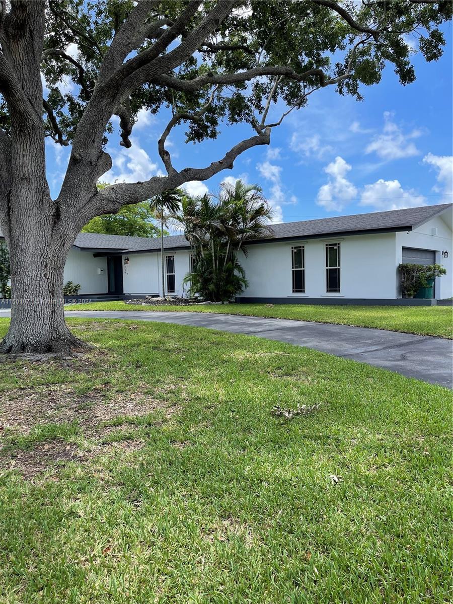 a front view of house with yard and trees