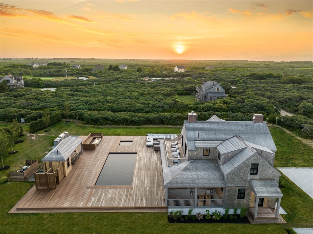 an aerial view of residential houses with outdoor space and city view