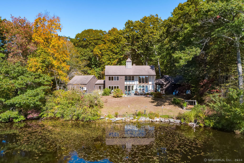 a view of a house with a big yard and large trees