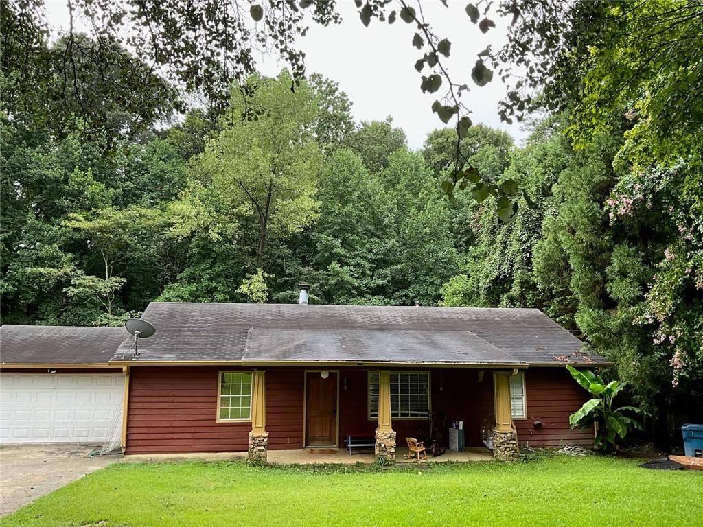 a front view of a house with a garden and trees