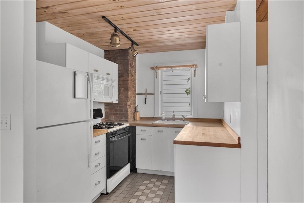 a kitchen with stainless steel appliances granite countertop refrigerator sink stove and white cabinets