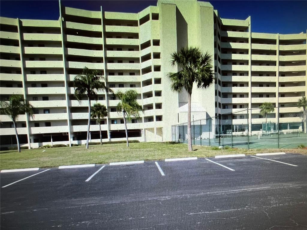 a view of a tall building in the middle of a yard