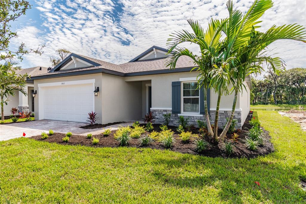 a white house with a small yard and palm trees