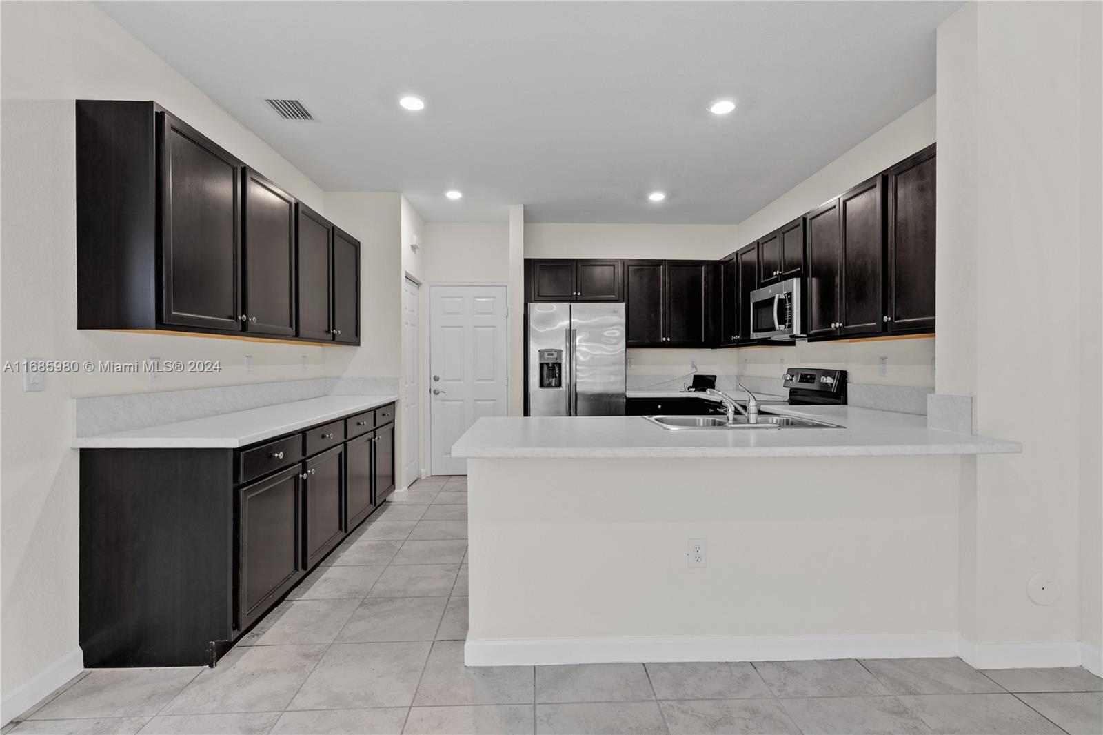 a large white kitchen with stainless steel appliances