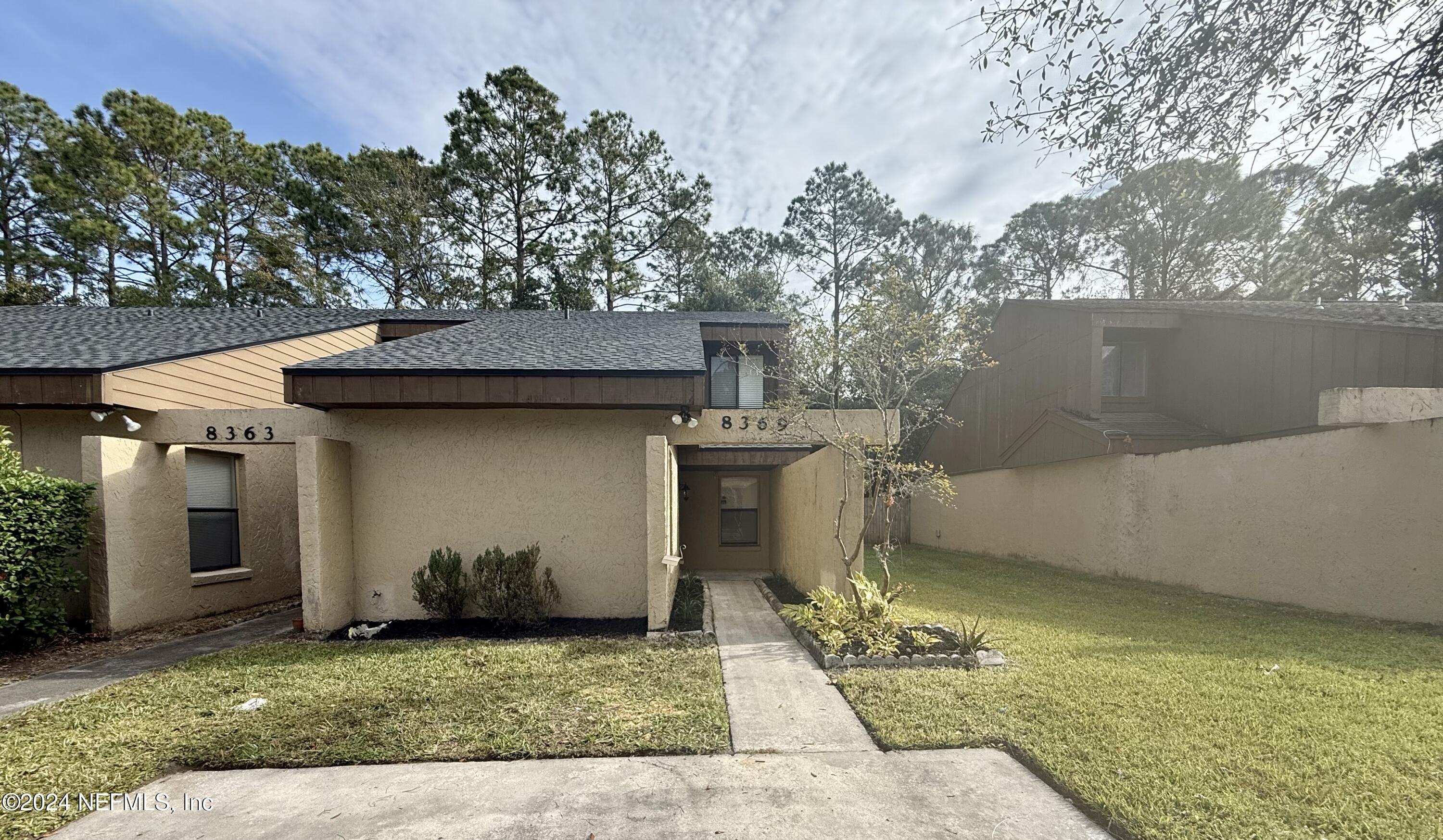 a view of a house with roof and a tree